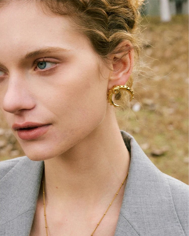 Stylish young woman models old Crescent Moon Earrings, close up