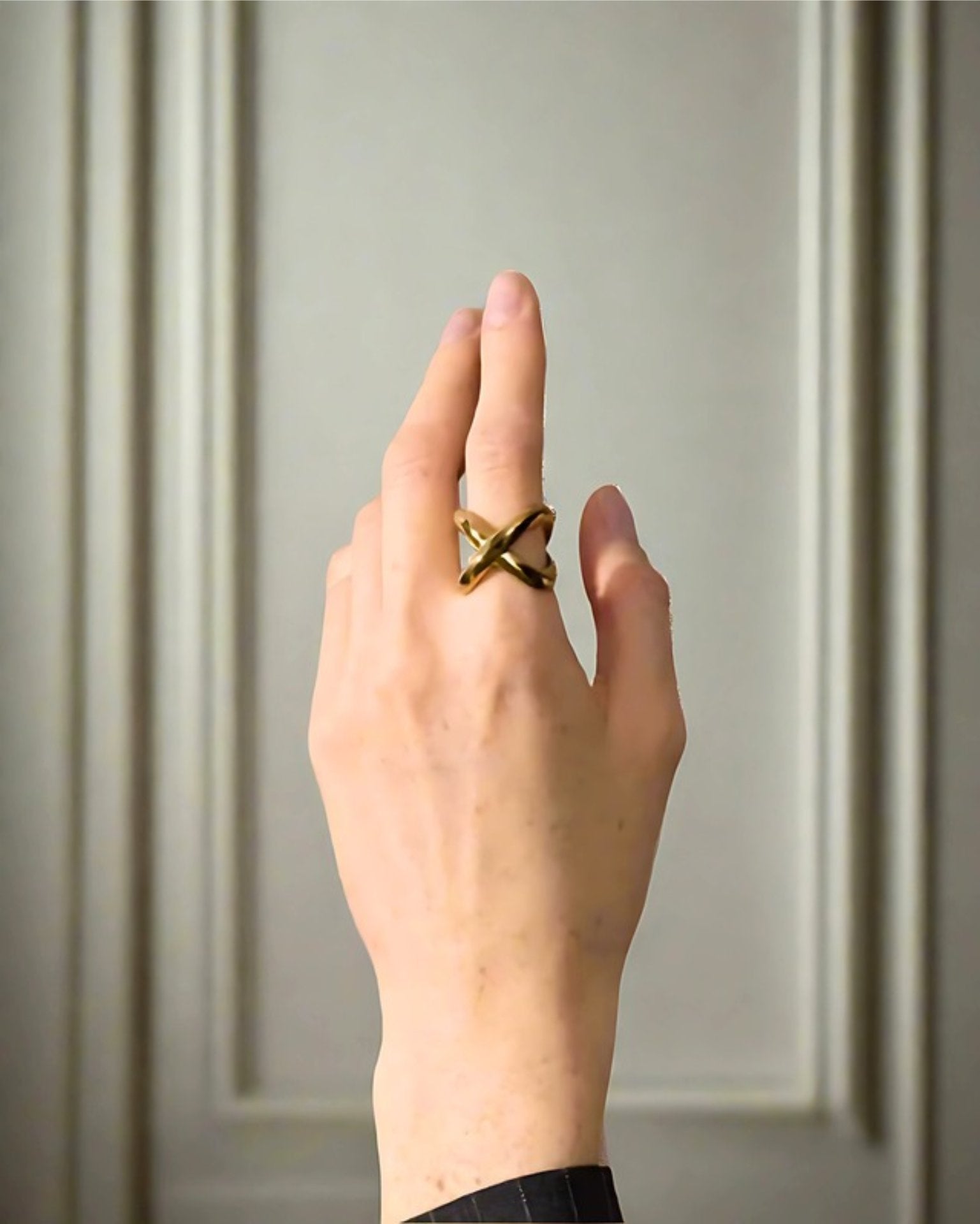 Elegant, young woman models Geometric Crossover Statement Ring, hand close up