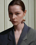 Stylish, young woman models Gold Statement Orb Hoop Earrings, angle 1