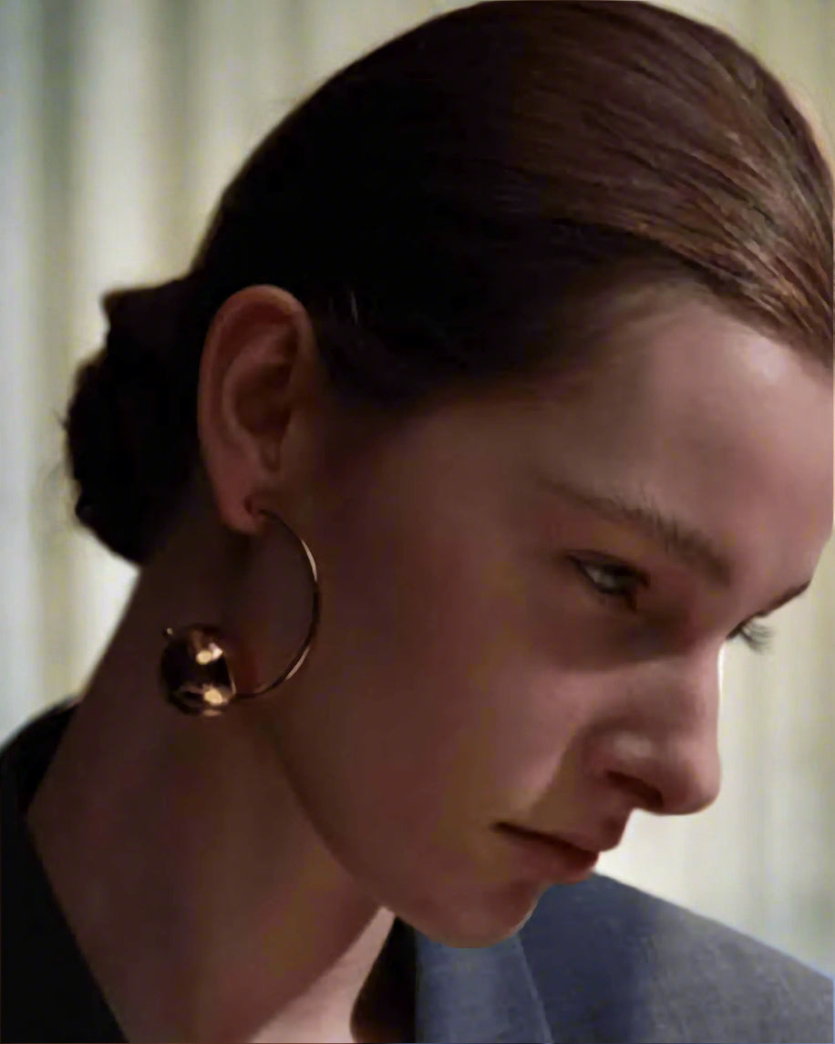 Stylish, young woman models Gold Statement Orb Hoop Earrings, angle 7