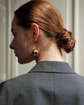 Stylish, young woman models Gold Statement Orb Hoop Earrings, angle 2