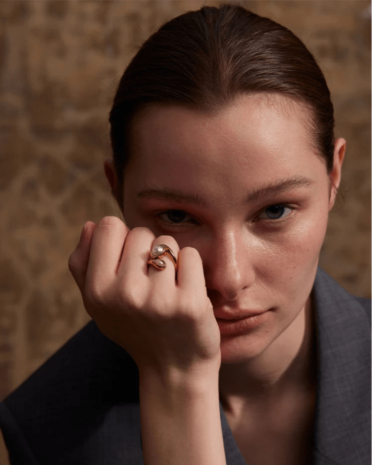 Elegant, young woman models Gold Asymmetrical Bypass Pearl Ring, close up 1