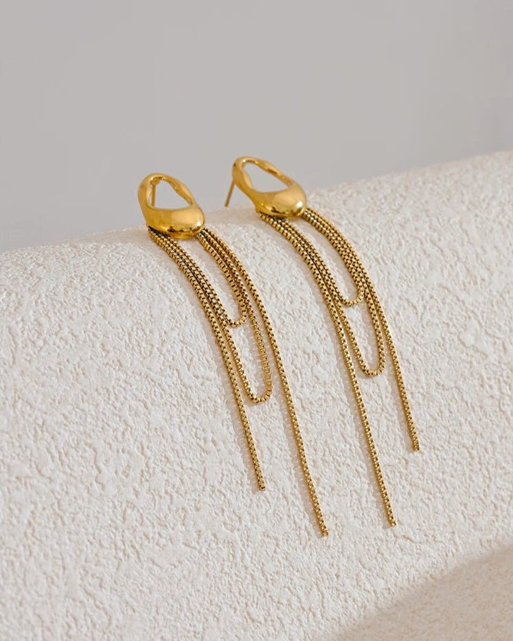 Gold Asymmetrical Chain Tassel Earrings on display