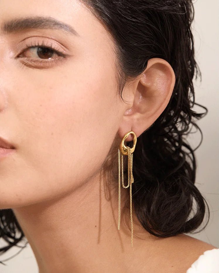 Gold Asymmetrical Chain Tassel Earrings against white background