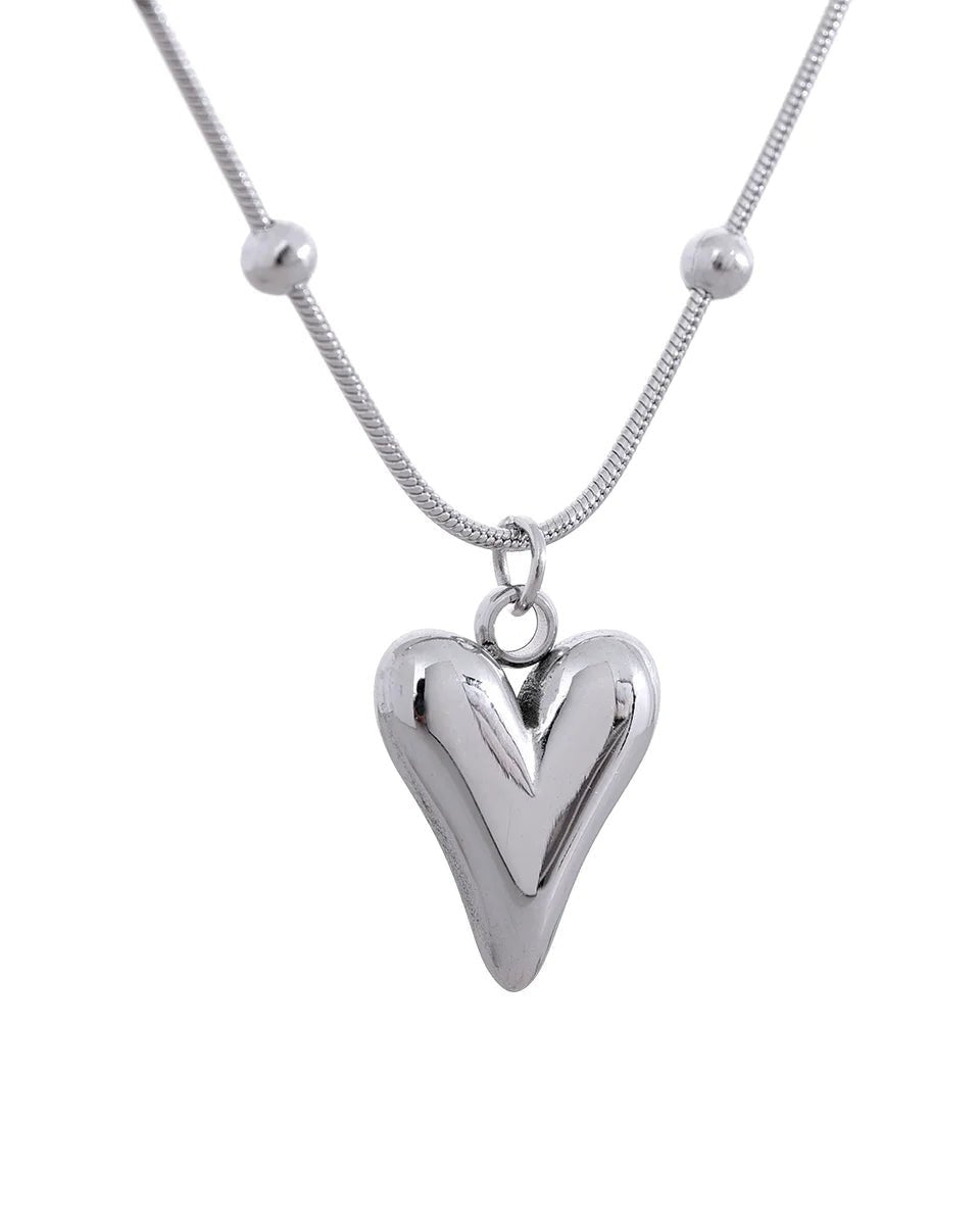 Silver Asymmetrical Heart Pendant Necklace, station chain variant, on white background