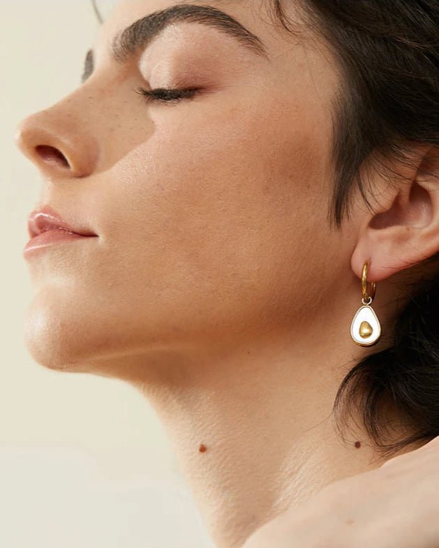 Stylish young woman models Avocado Sculpted Drop Earrings, angle 1