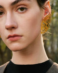 Elegant, young woman models Gold Butterfly Wing Statement Earrings, angle 5