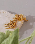 Gold Cascading Ball Chain Drop Earrings on display over limestone