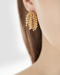 Young model wearing Gold Cascading Ball Chain Drop Earrings, close up