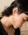 Elegant young woman models Gold Cascading Tassel Hoop Earrings, left side