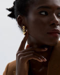 Stylish woman models Gold Chunky Hoop Statement Earrings, angle 3