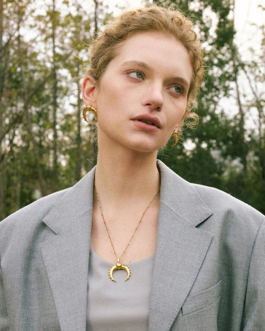 Stylish young woman models Gold Crescent Moon Earrings portrait 2