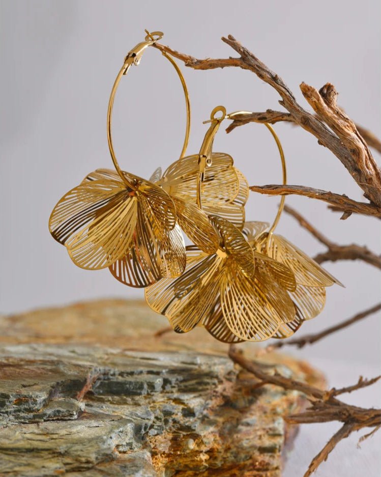 Gold Flower Motif Hoop Earrings dangling on branch display