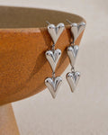 Silver Heart Charms Dangle Earrings, displayed against vase